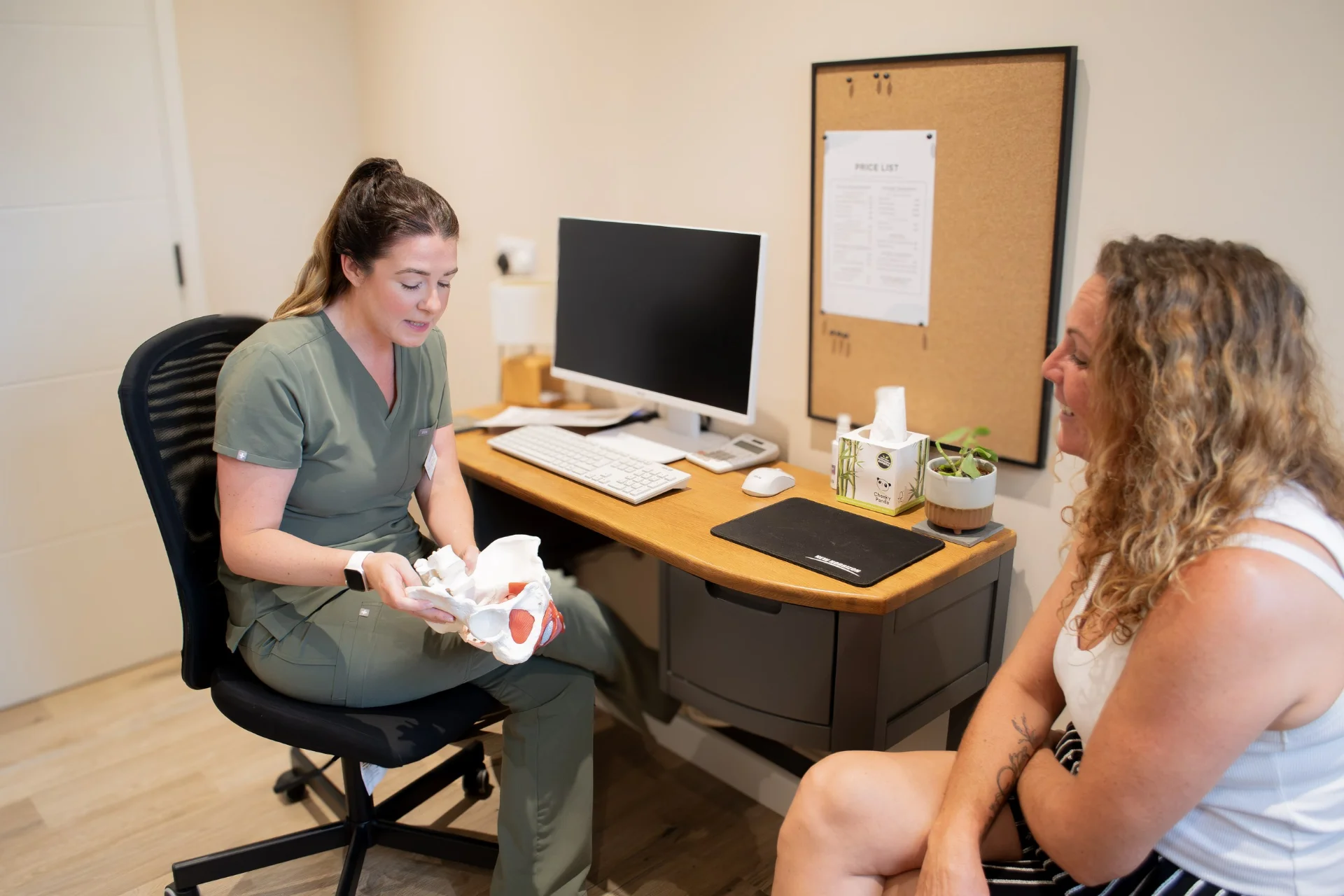 Physiotherapist talking a patient through pelvic anatomy during an appointment