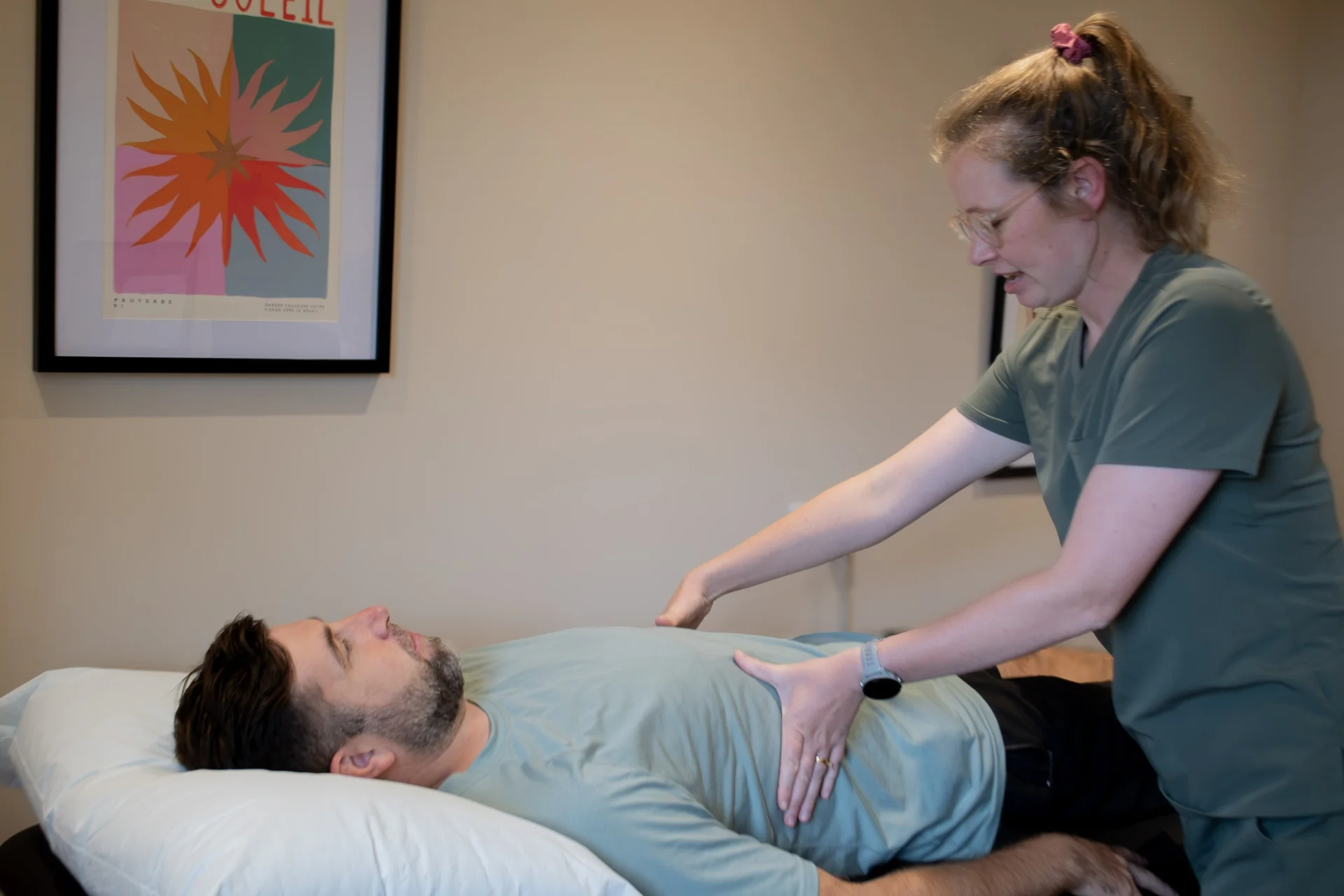 Physiotherapist gently assessing a patient's abdomen